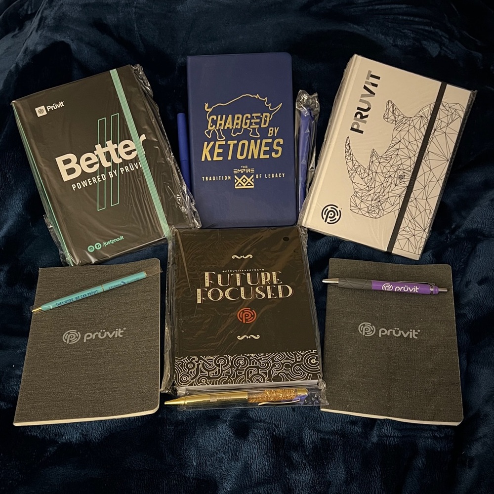 Pruvit Assortment of notebooks and pens